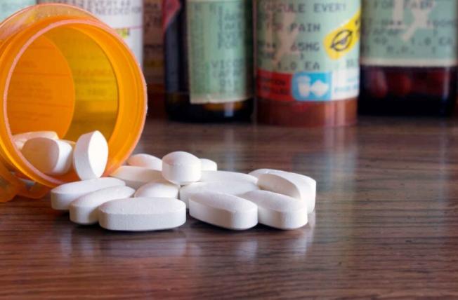 Opioids, bottle of pills spilled on a table
